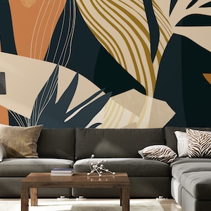 May include: A living room interior design featuring a sectional sofa with cushions, a coffee table, and a floor lamp. The wall behind the sofa is decorated with a large abstract print featuring a pattern of leaves and stripes in shades of beige, brown, and blue.