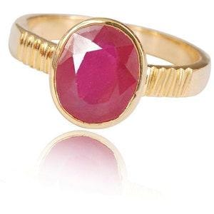 Op de afbeelding: Een gouden ring met een grote, ovaal geslepen, donkerroze edelsteen in een zetting. De ringband heeft aan beide zijden van de centrale steen een gestructureerd, geribbeld ontwerp, wat een duidelijk contrast vormt met de gladde gouden afwerking.