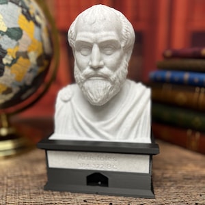 May include: A white bust sculpture of Aristotle on a black base with the text "Aristotle 384-322 BC".