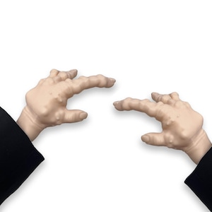 Puede incluir: Dos manos con piel arrugada están extendidas, apuntando con sus dedos índices. Las manos llevan mangas negras.