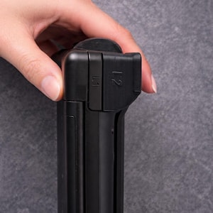 May include: A black gaming controller component featuring L1 and L2 shoulder buttons. The device has a matte finish with textured grip areas on the top section. The L1 and L2 labels are clearly embossed on the side of the black plastic housing.
