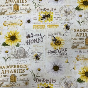 Puede incluir: Una tela blanca con un patrón repetido de abejas, panales, girasoles, margaritas y texto con temática de abejas. El texto incluye "Saugerbees Apiaries", "Sweet Honey", "The Bee Hive", "Farm Fresh" y "Honey Bee Farm".