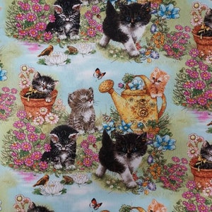 May include: A colorful fabric with a repeating pattern of kittens, flowers, and watering cans. The kittens are in various poses, some are sitting, some are standing, and some are playing. The flowers are in shades of pink, purple, and yellow. The watering cans are yellow and have a floral design.