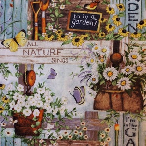 May include: A colorful fabric with a garden theme. It features a blue wooden fence, flowers, butterflies, birds, and gardening tools. The fabric has the text "All Nature Sings" and "I'm in the Garden!" on it.