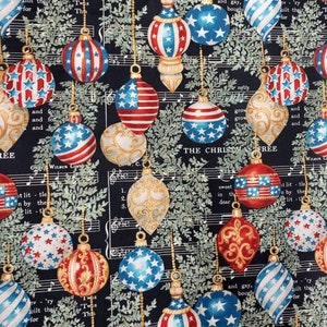 May include: A black fabric with a repeating pattern of red, white, and blue Christmas ornaments. The ornaments are decorated with stars and stripes. The fabric has a musical note background with the words "The Christmas Tree" printed on it.