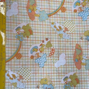 Peut inclure: Tissu à motifs répétés d'animaux de dessins animés, d'arcs-en-ciel et de formes en orange, jaune, bleu et vert. Le fond est un motif quadrillé avec des lignes orange, jaune et vert. Idéal pour les articles pour enfants.