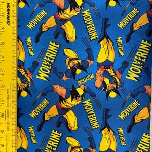 Peut inclure: Tissu bleu avec un motif répété du super-héros Wolverine. Le motif présente Wolverine en jaune et bleu, avec le mot "Wolverine" en blanc. Idéal pour les projets de couture ou les vêtements.