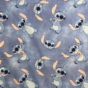 Puede incluir: Tela azul y blanca con un patrón repetido de Stitch, un personaje alienígena azul de la película de Disney Lilo & Stitch. Stitch se muestra en varias poses, incluyendo sosteniendo un corazón.