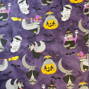 May include: Purple fabric with a repeating pattern of sloths dressed in Halloween costumes. The sloths are dressed as a witch, a vampire, a mummy, and a bat. They are holding pumpkins, brooms, and bats. The background is a dark purple with stars and bats.
