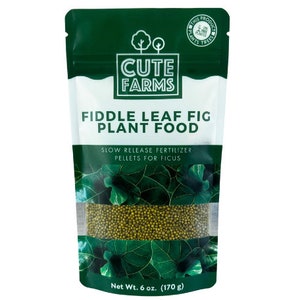 May include: A green pouch with a white label that reads "CUTE FARMS" and "FIDDLE LEAF FIG PLANT FOOD". The pouch contains slow-release fertilizer pellets for ficus plants. The pouch has a clear window showing the green pellets. The label also states "Net Wt. 6 oz. (170 g)".