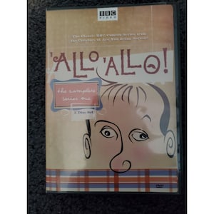 以下が含まれることがあります： BBCのコメディシリーズ「'Allo 'Allo!」のDVD。シリーズ1の完全版、2枚組。カバーには、番組タイトルを大きくあしらった男性の顔の漫画イラストが描かれています。BBC Videoのロゴが上部にあります。