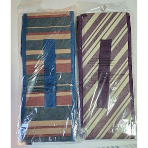 May include: Two rectangular, foldable tote bags in plastic packaging. One has blue, red, and tan horizontal stripes with a blue handle. The other has purple and cream diagonal stripes with a purple handle. Both are new.