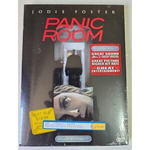 May include: A DVD case for the film Panic Room starring Jodie Foster. The black cover features a silhouette in a doorway and a close-up of a face. It includes a red Superbit sticker, a yellow Best Buy price sticker, and a blue inventory label.