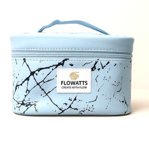 Pode incluir: Uma bolsa de maquilhagem azul claro com um padr&atilde;o de m&aacute;rmore e uma pega a condizer. A bolsa tem um fecho de correr e uma etiqueta branca com o texto "FLOWATTS CREATE WITH FLOW". A bolsa &eacute; retangular e parece ser feita de um material dur&aacute;vel.