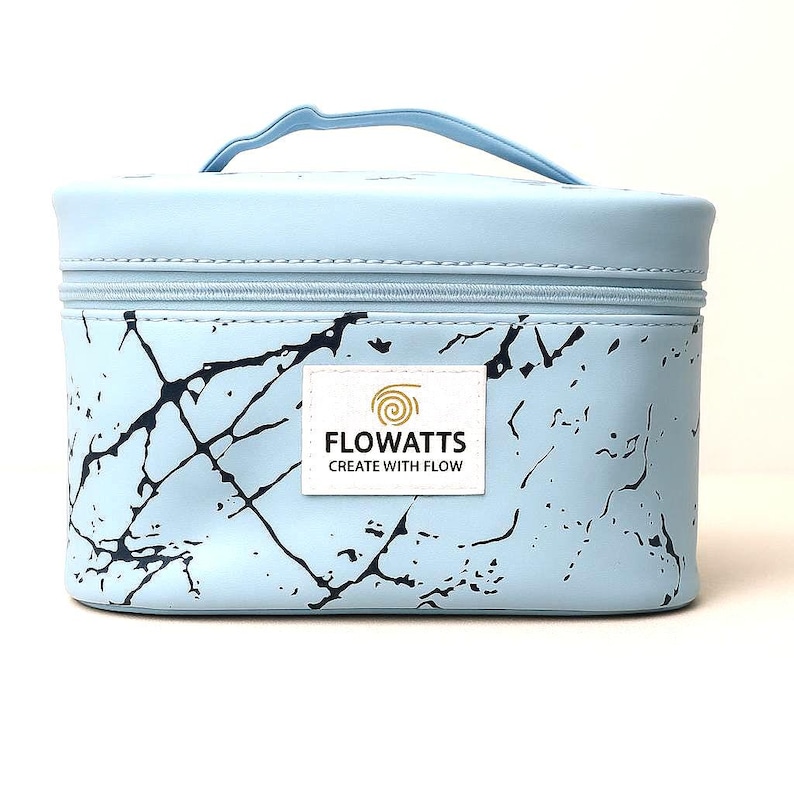 Pode incluir: Uma bolsa de maquilhagem azul claro com um padr&atilde;o de m&aacute;rmore e uma pega a condizer. A bolsa tem um fecho de correr e uma etiqueta branca com o texto "FLOWATTS CREATE WITH FLOW". A bolsa &eacute; retangular e parece ser feita de um material dur&aacute;vel.