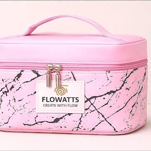 Pode incluir: Bolsa de maquilhagem rosa com pega e padr&atilde;o marmoreado. A bolsa tem fecho de correr e uma pequena etiqueta com a inscri&ccedil;&atilde;o "FLOWATTS CREATE WITH FLOW". Concebida para guardar cosm&eacute;ticos e produtos de beleza.