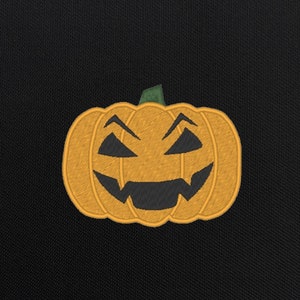 May include: A bright orange jack-o'-lantern with a carved, toothy grin and green stem. The pumpkin is embroidered on a black fabric background.
