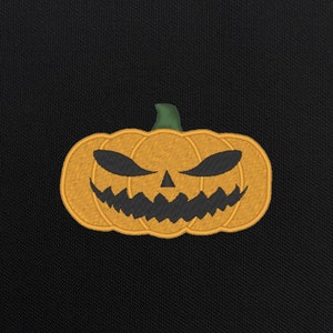 May include: A black background with an orange embroidered jack-o'-lantern with a scary face.