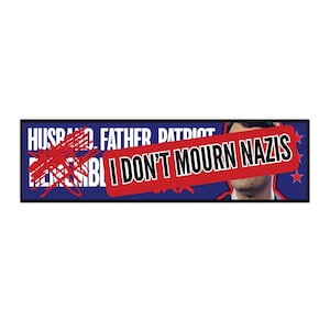 May include: A rectangular sticker with a blue background and white text that reads "HUSBAND. FATHER. PATRIOT." crossed out with red scribbles. A red banner with white text that reads "I DON'T MOURN NAZIS" is overlaid. The image includes a partial face.