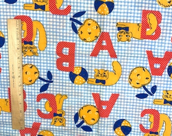 May include: Blue and white gingham fabric with red letters, yellow flowers, and orange cats wearing blue bow ties. The letters are A, B, and C. The fabric is perfect for quilting, crafts, and other sewing projects.