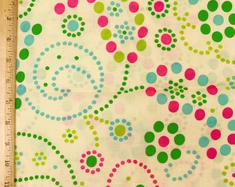 May include: A white fabric with a repeating pattern of green, pink, and blue circles. The circles are arranged in a swirling pattern.