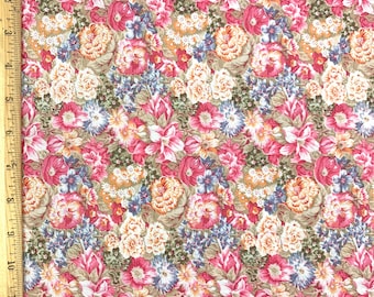 May include: Floral fabric with a dense pattern of pink, red, blue, and cream-colored flowers on a tan background. The fabric is measured with a wooden ruler, showing a scale in inches.