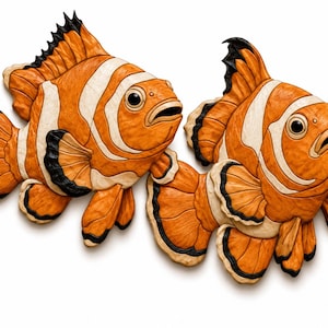 May include: Two carved wooden fish sculptures featuring a vibrant orange body with distinct white vertical stripes and black-tipped fins. Each fish has a textured surface, a wide open mouth, and a large dark eye, showcasing detailed craftsmanship.
