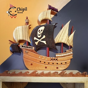 May include: A wooden pirate ship with a black skull and crossbones flag, intricate details, and a wood grain finish. The ship is mounted on a wooden base with waves carved into it. The text "Chipil Wood" is visible in the top left corner of the image.