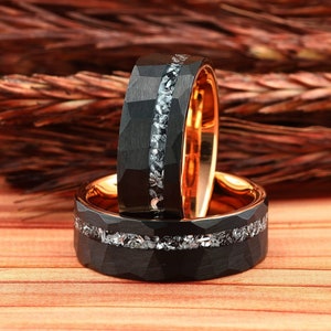 May include: Two black tungsten carbide rings with a row of small diamonds set into the band. The rings are stacked on top of each other.