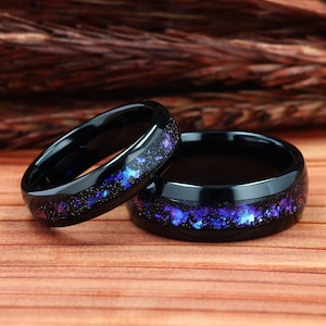 Pu&ograve; includere: Due anelli in carburo di tungsteno nero con un designo a galassia viola e blu. Gli anelli sono lucidati e hanno un'alta lucentezza.