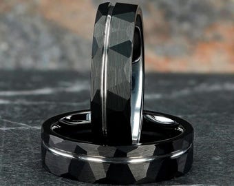May include: Two black tungsten carbide wedding bands with a beveled edge and a brushed finish. The bands have a silver inlay.