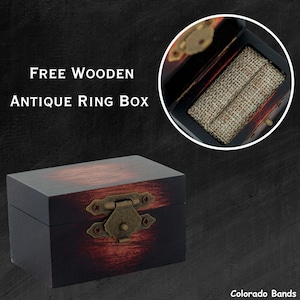 May include: A dark wood ring box with a hinged lid and a brass latch. The box has a distressed finish and is lined with a brown fabric. The text "FREE WOODEN ANTIQUE RING BOX" is visible in the image.