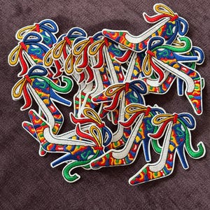 Puede incluir: Una taza de cerámica blanca con asa negra y el texto "But First, Coffee" en negro, con una fuente de estilo manuscrito. La taza está sobre una superficie blanca.