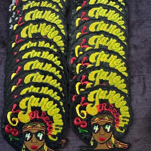 Può includere: Toppe ricamate raffiguranti una donna con grandi occhiali da sole, labbra rosse e un grande afro. Le toppe hanno la scritta "Queenete" in giallo. I capelli della donna sono verdi e gialli, con accenti rossi. Le toppe sono nere con paillettes.