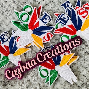 Può includere: Toppe ricamate con un design a forma di stella con accenti bianchi, rossi, blu, gialli e verdi. Le toppe presentano le lettere "ESS" e "E" in grassetto. È visibile anche un cartello viola con il testo "Cazbaa Creations".