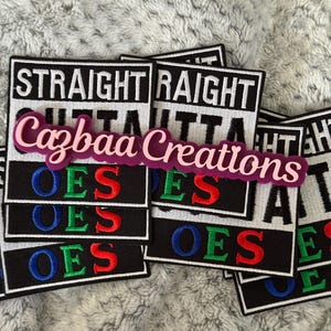 Op de afbeelding: Een verzameling zwart-witte geborduurde patches met de woorden "STRAIGHT OUTTA" en "OES" in rood, groen en blauw. Een roze en paars Cazbaa Creations logo is erop afgebeeld.