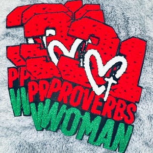 Könnte beinhalten: Rote und grüne Aufkleber mit der Aufschrift „Proverbs 31 Woman“. Die Aufkleber zeigen den Text „Proverbs 31 Woman“ in grünem Glitzer-Schriftzug, mit den Zahlen „31“ in Rot und einem weißen Herz mit einem Kreuz.
