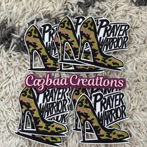 Könnte beinhalten: Eine Sammlung von Aufklebern mit hochhackigen Schuhen mit einem Tarnmuster in Grün, Braun und Schwarz. Jeder Aufkleber trägt die Worte "Prayer Warrior" und den Text "Cazbaa Creations".