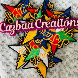 以下が含まれることがあります： 赤、青、黄、緑、白など、さまざまな色の刺繍された星のパッチ。各パッチには、筆記体フォントで「Stars Forever」という言葉が書かれています。パッチは、グレーのテクスチャのある表面に積み重ねられています。