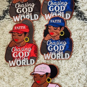 May include: Embroidered patches featuring a woman in a cap, with the text "FAITH" and "Chasing God not the World." The patches are in various colors: black, blue, red, and pink. The patches have gold hoop earrings and red lipstick.
