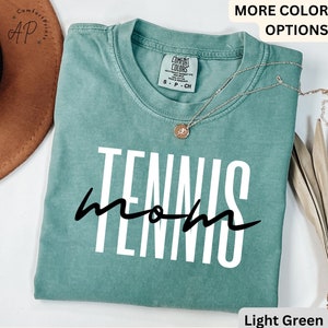May include: Light green t-shirt with the text "Tennis Mom" in white and black lettering.