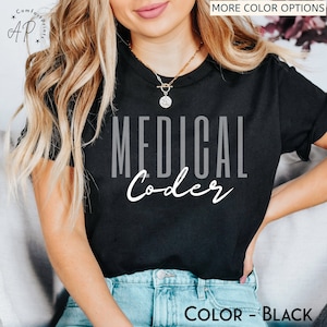 Peut inclure: T-shirt noir avec le texte "MEDICAL Coder" en lettres blanches et grises. Le t-shirt est porté par une personne aux cheveux blonds longs.