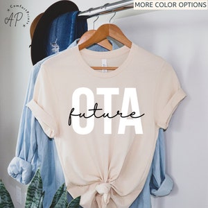 May include: A beige t-shirt with the text "OTA future" printed in white on the front.
