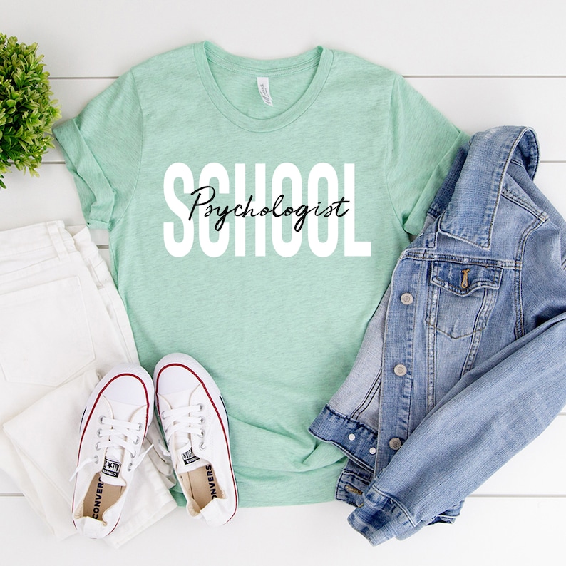 Op de afbeelding: Een lichtgroen T-shirt met de tekst "School Psychologist" in witte letters.