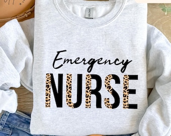 May include: A gray sweatshirt with the text "Emergency Nurse" in black lettering. The word "Nurse" is printed with a leopard print pattern.