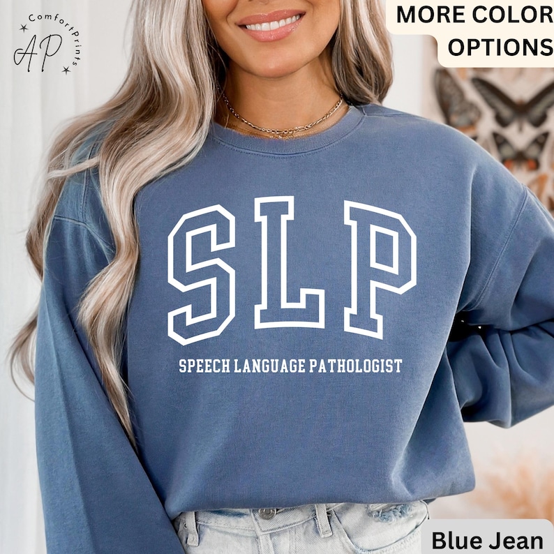 May include: A blue sweatshirt with white text that reads "SLP" and "Speech Language Pathologist".