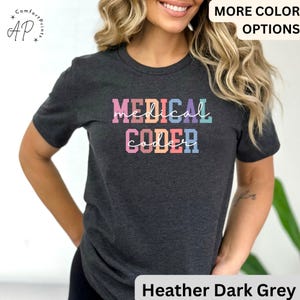 May include: Heather dark grey t-shirt with the text "MEDICAL CODER" in rainbow colors. The text is in a bold, blocky font.