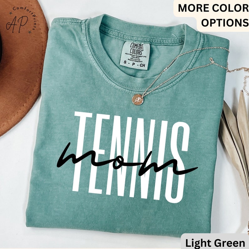 May include: Light green t-shirt with the text "Tennis Mom" in white and black lettering.
