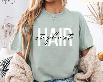 May include: A light green t-shirt with the text "Hair Stylist" in white letters with a black outline.