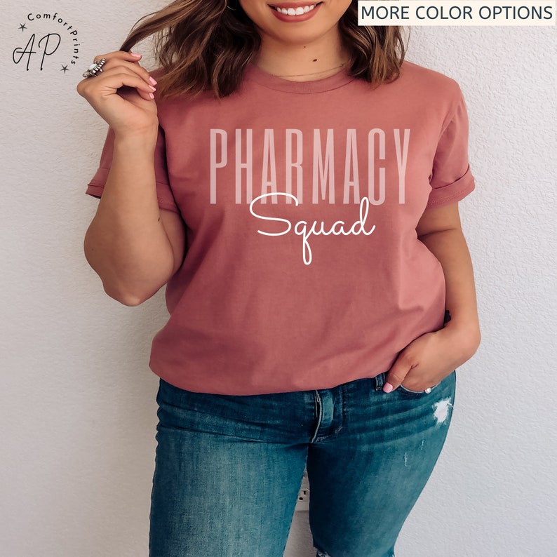 May include: A mauve t-shirt with the text "Pharmacy Squad" in white lettering.